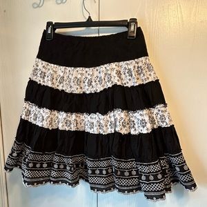 Young trendy black and white striped skirt with variety of different materials.
